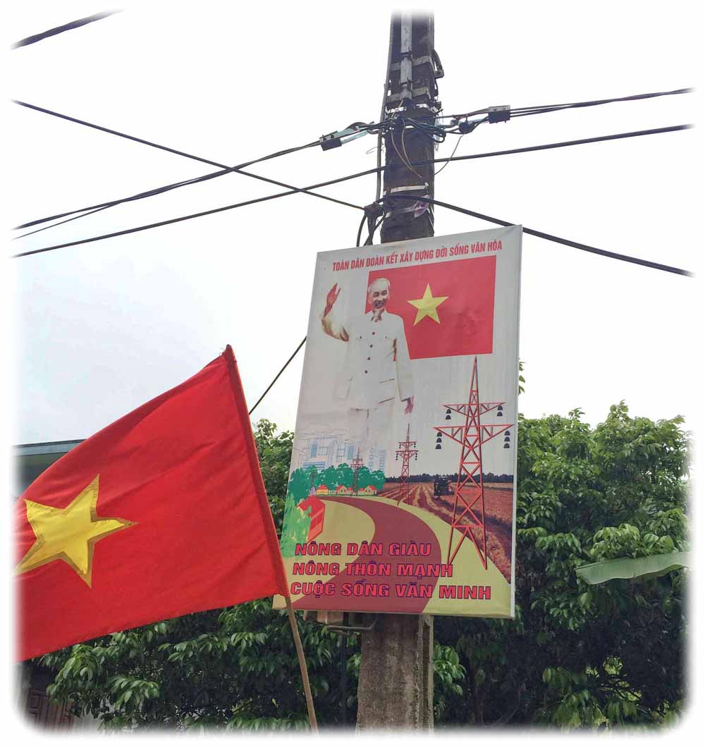 Altes Ho-Chi-Minh-Propaganda-Plakat und Fahne auf einer Insel im Norden Vietnams. Foto: Heiko Weckbrodt