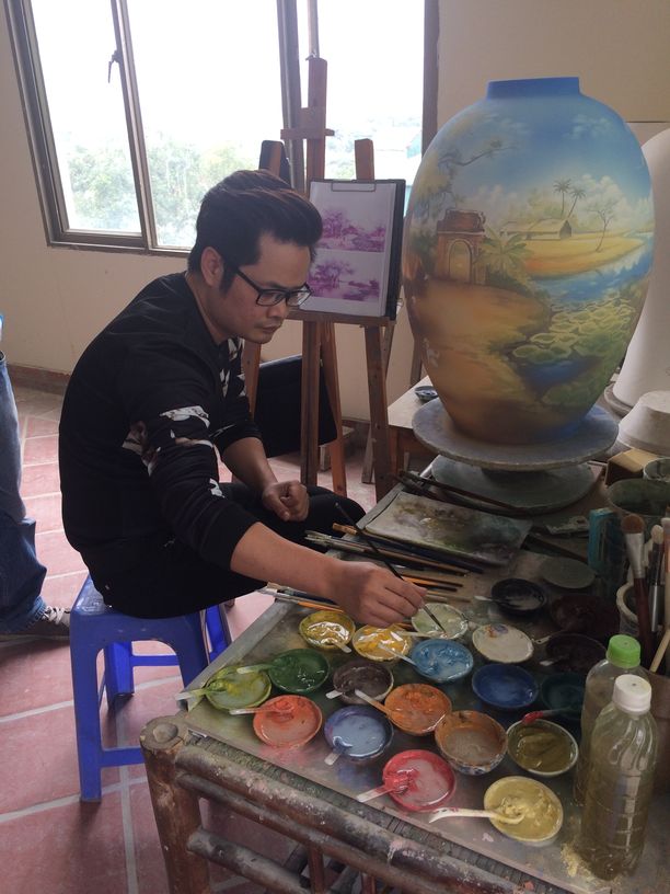Ein Künstler bemalt in der Keramikmanufaktur in Bat Trang eine Vase. Foto: Heiko Weckbrodt