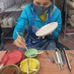 Eine Mitarbeiterin bemalt in der Keramikmanufaktur in Bat Trang eine Schale. Foto: Heiko Weckbrodt